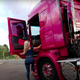 Screenshot of driver climbing into her pink truck